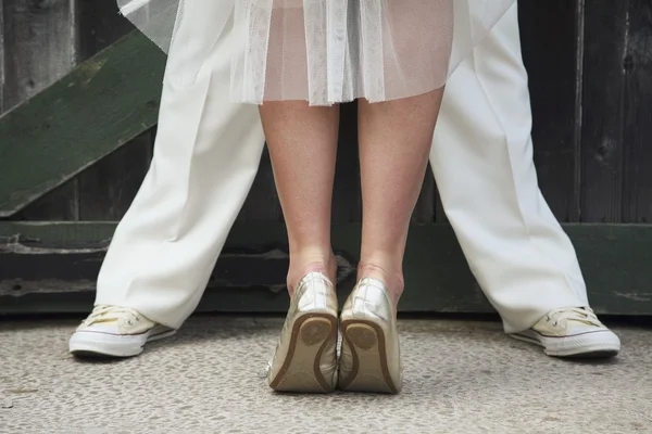 Sposa in piedi sulle punte dei piedi davanti a uno sposo — Foto Stock