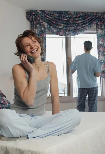 Fru chattar på telefon medan man väntar — Stockfoto