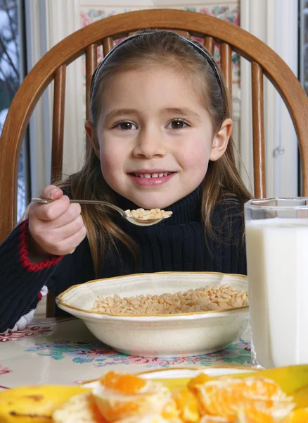 朝食のテーブルで穀物を食べる若い女の子 — ストック写真