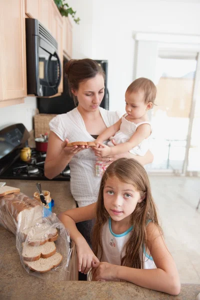 Мама делает бутерброд для своих девочек — стоковое фото