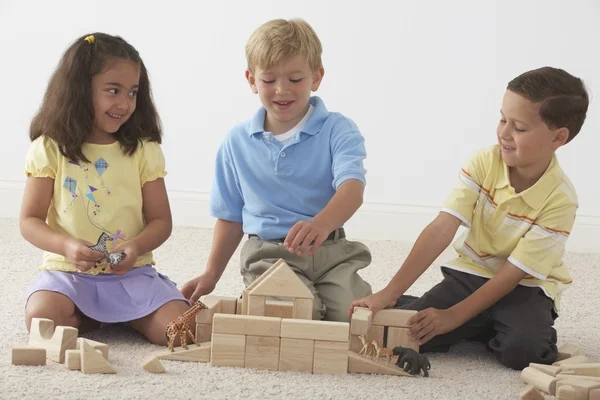 Tre barn bygga Noaks ark med träklossar — Stockfoto