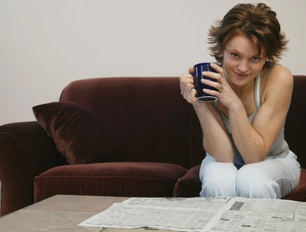 Frau trinkt Kaffee und liest Zeitung — Stockfoto