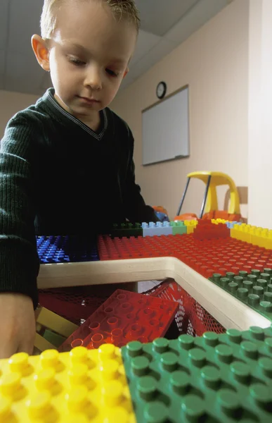 Ung pojke leker med stora lego block — Stockfoto