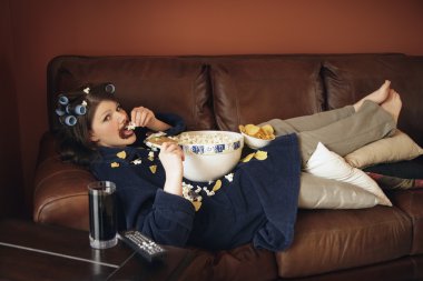 Girl on the couch eating popcorn clipart