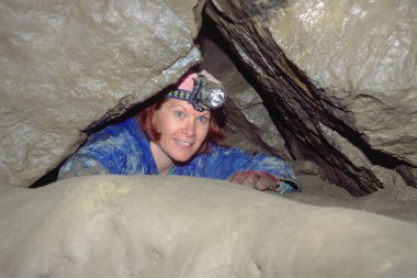 Woman Exploring Underground Cave clipart