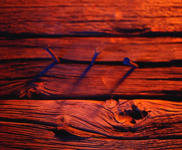 Trzy gwoździe w drewnie w odcieniach czerwieni — Zdjęcie stockowe