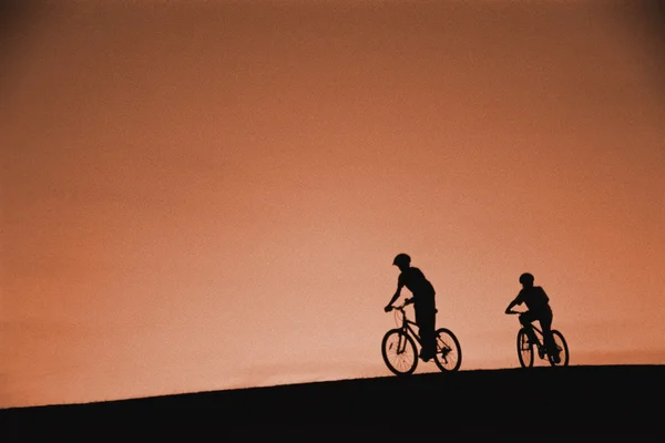 Silhouette dei ciclisti sulla collina — Foto Stock