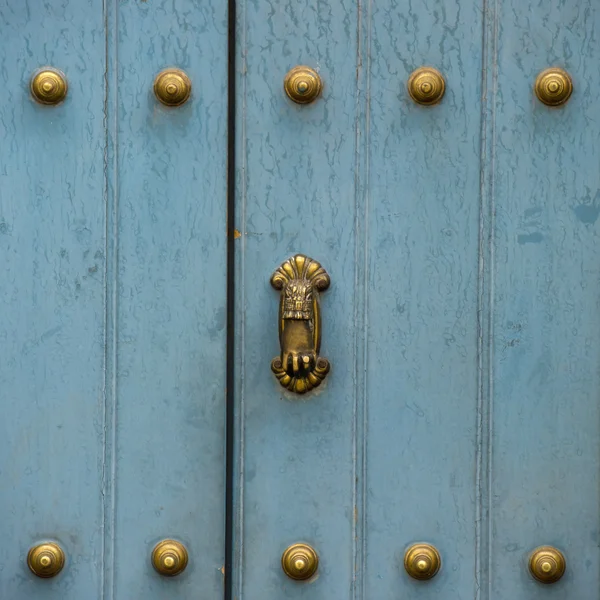 Una porta blu con manopole decorative in ottone — Foto Stock