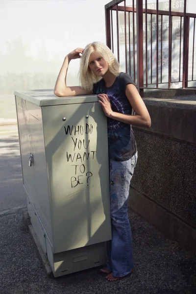 Jovem mulher encostada a um poste — Fotografia de Stock
