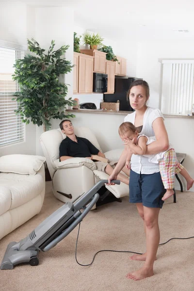 Mother Trying To Vacuum While The Father Sits Around — Stock Photo, Image