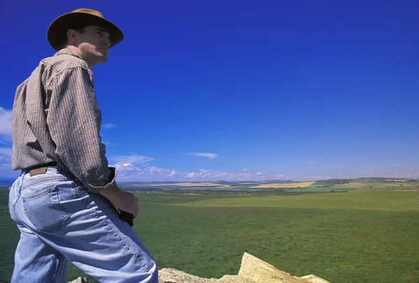 Турист с биноклем на краю скалы — стоковое фото