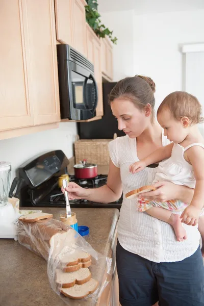 Moeder maakt een sandwich voor zijn kleine meisje — Stockfoto