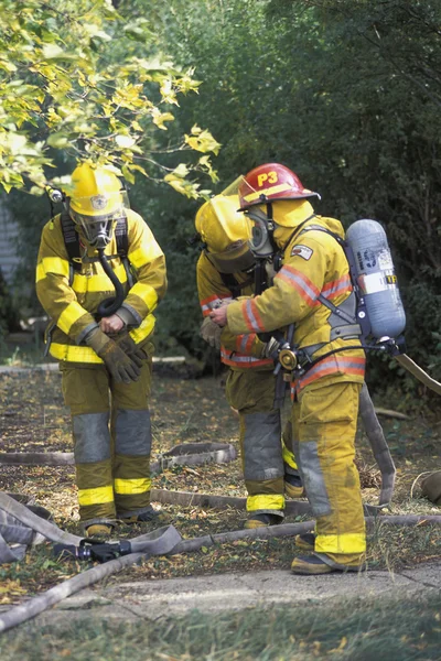 Feuerwehrleute ziehen Ausrüstung an — Stockfoto