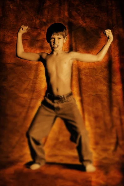 Pojken spänner musklerna — Stockfoto