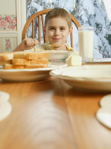 少年が朝食のテーブルで穀物を食べて — ストック写真