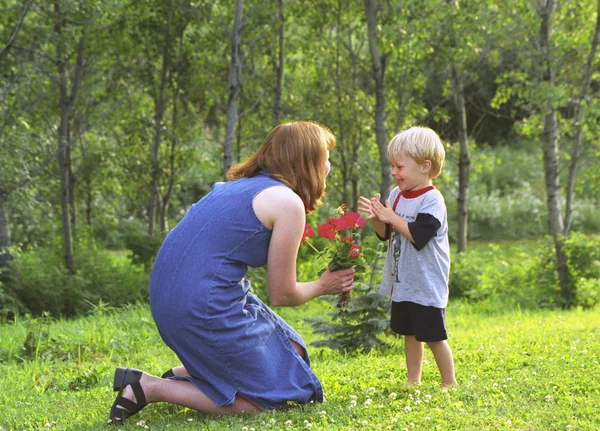 Mother And Son With Flowers In Park — Stock Photo, Image