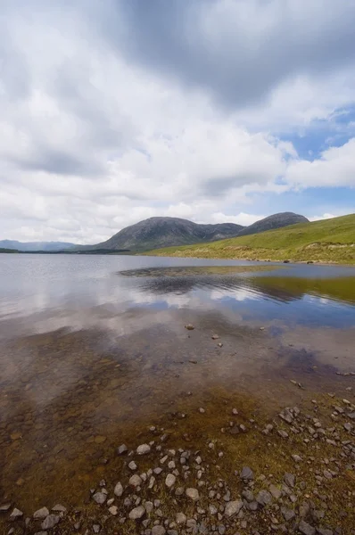 Cielo reflejado en aguas poco profundas con montañas — Foto de Stock