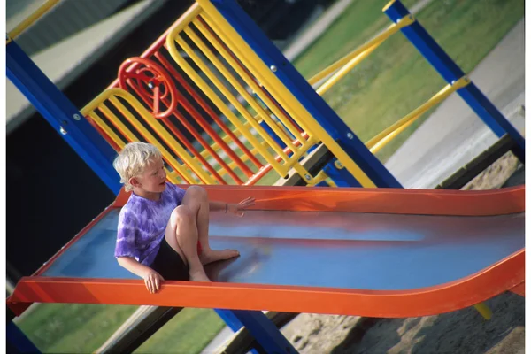 Criança descendo um slide — Fotografia de Stock