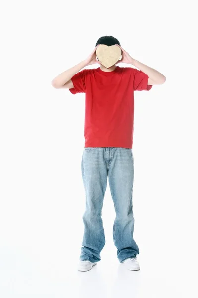 Niño con corazón cubriendo su cara — Foto de Stock