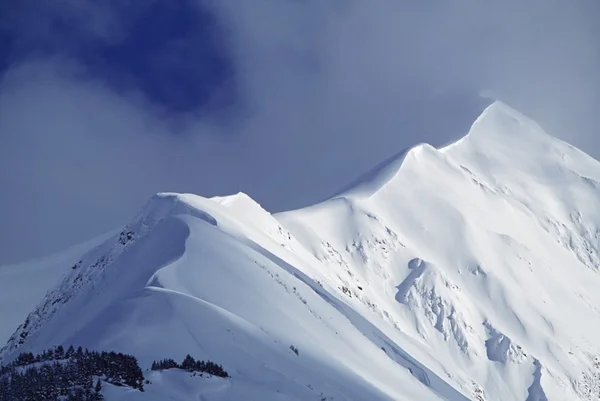 Nieve cornisa que conduce a la cima de la montaña —  Fotos de Stock