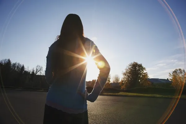 Vigas de luz solar e um brilho circular em torno de uma adolescente — Fotografia de Stock