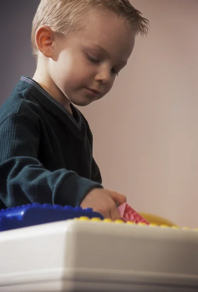 Ung pojke leker med stora lego block — Stockfoto