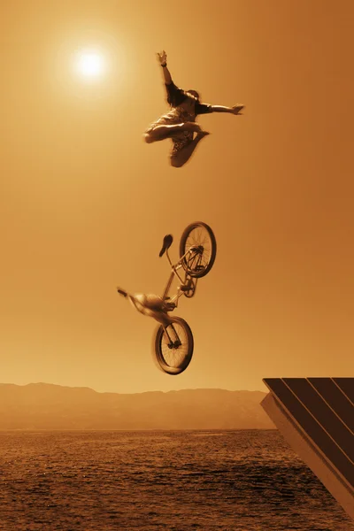 Cyclist Going Off Jump Into Water In Brown Tones — Stock Photo, Image