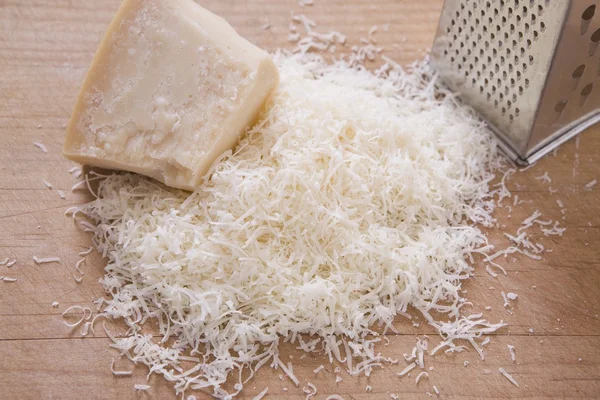 Shredded Parmeson Cheese On A Cutting Board With A Grater — Stock Photo, Image