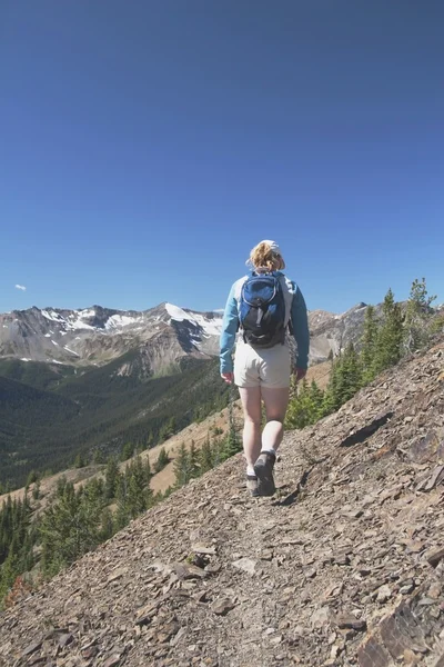 Frau wandert auf Bergpfad — Stockfoto