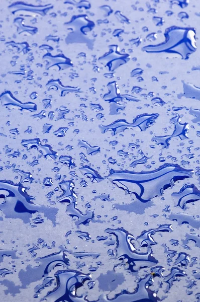 Gotas de água em uma superfície azul — Fotografia de Stock