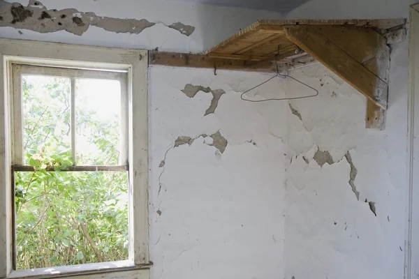Prateleira de canto de madeira e janela ao longo de uma parede com pintura de descascamento — Fotografia de Stock