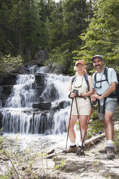 Pareja senderismo cerca de una cascada —  Fotos de Stock