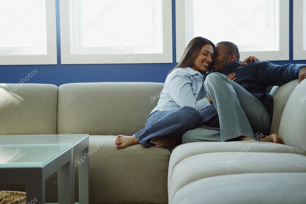 Couple Snuggles On Sofa