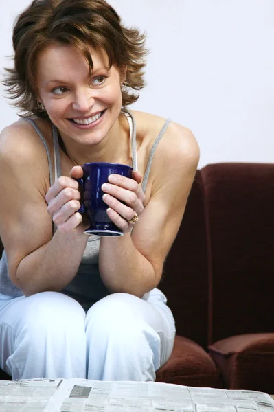 Frau trinkt Kaffee und liest Zeitung — Stockfoto