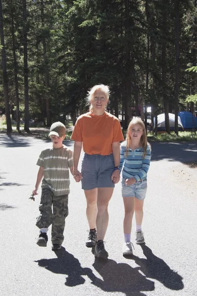 Mujer camina con un niño y una niña en un camping — Foto de Stock