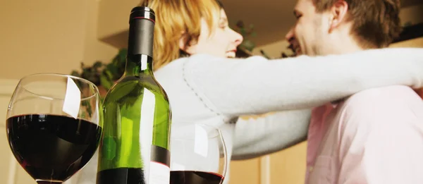 Пара празднующих с бутылкой вина — стоковое фото