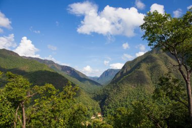 Karmaşık dağ manzarası, yemyeşil, nehirler, dereler, açık gökyüzü.