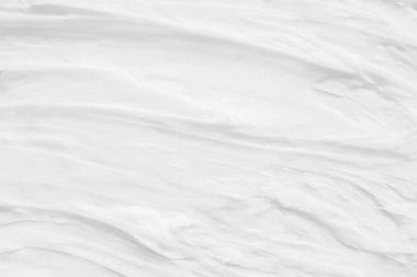 Krem losyonun beyaz yüzeyi arka planı yumuşatır..