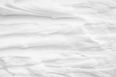 Krem losyonun beyaz yüzeyi arka planı yumuşatır..