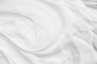 Krem losyonun beyaz yüzeyi arka planı yumuşatır..