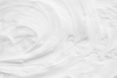 Krem losyonun beyaz yüzeyi arka planı yumuşatır..