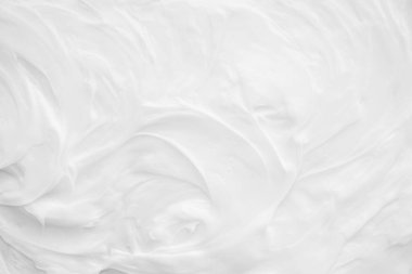 Krem losyonun beyaz yüzeyi arka planı yumuşatır..