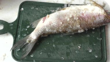 Şef çiğ balığı bıçakla soyar. 