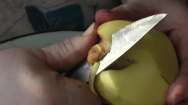 Şef patatesleri bıçakla soyar. 