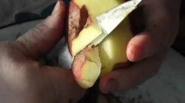 Şef çiğ patatesleri bıçakla soyar. 