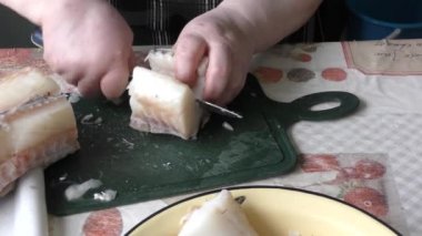 the chef cuts a cod fish with a knife 