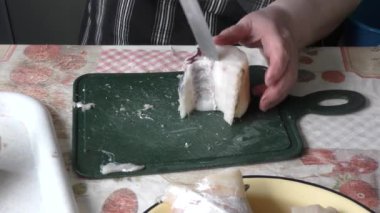 the chef cuts a cod fish with a knife 