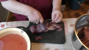 Şef bıçakla geyik eti keser. 