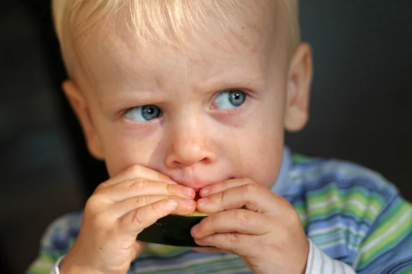 Ragazzino mangiare un melone Foto Stock