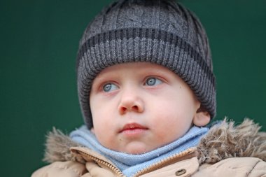 Çocuk şapkası takıyor